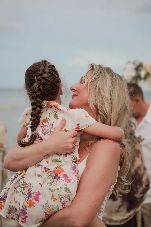 La novia abraza a una niña con trenzas