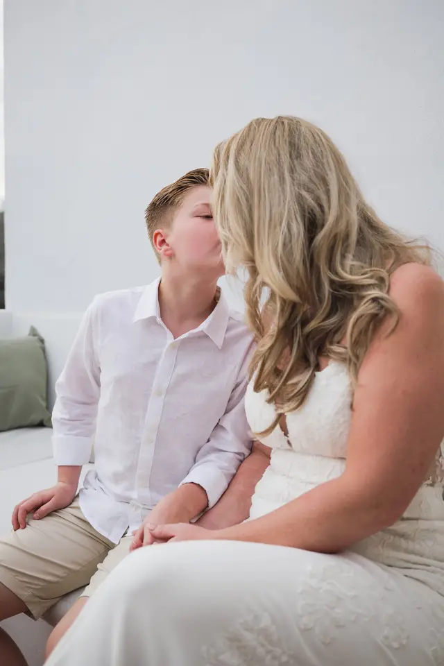 Un niño da un beso en la mejilla a la novia antes de la ceremonia
