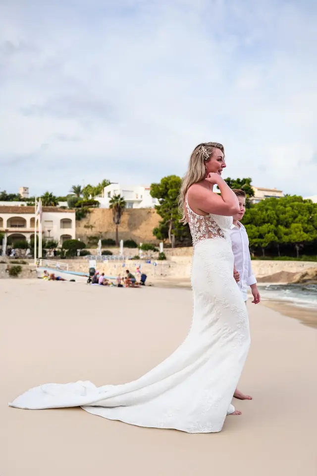La cola del vestido de novia extendida sobre la arena