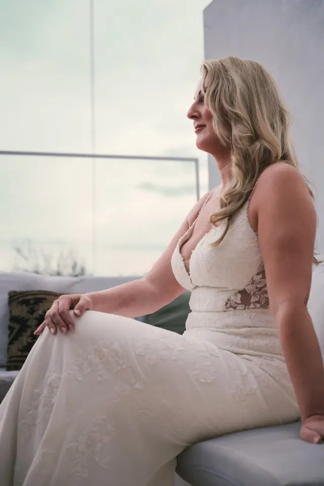 La novia sentada junto a la ventana, mirando hacia fuera antes de salir