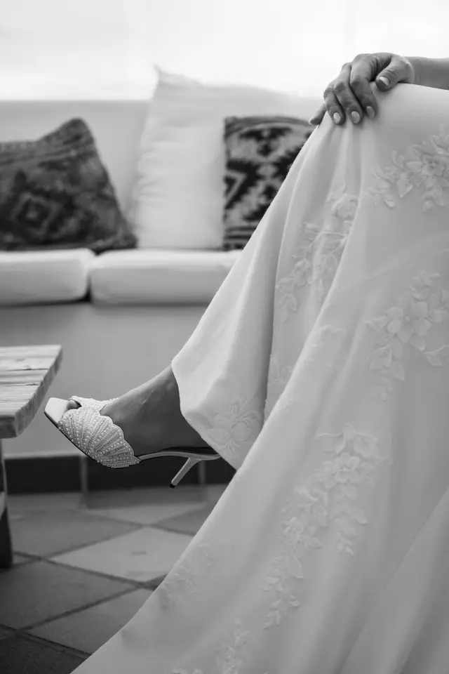 La novia se calza recogiendo la falda del vestido