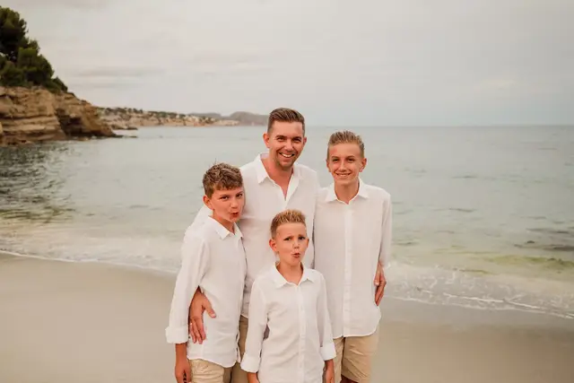El novio con tres niños en la orilla de la playa
